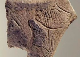 Plaquette calcaire figurant un profil de visage tourné vers la droite, mi-humain, mi-félin, les joues striées symbolisant peut-être un tatouage ou des scarifications,  découverte dans la grotte de la Marche (Vienne). Epoque magdalénienne (12 000 à 14 000 ans)