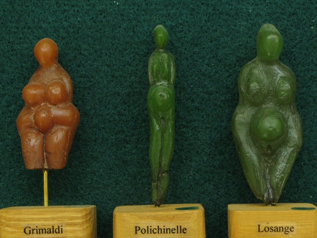 A gauche, statuette en stéatite jaune dite "Venus de Menton" découverte dans les grottes de Grimaldi (Ligurie/Italie). Gravettien vers 25000 BP - H=5 cm
